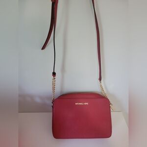 Michael Kors red crossbody bag with adjustable leather strap.